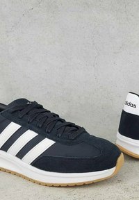 Tamno plavi ante sneakers s bijelim dizajnom od tri pruge, gumenim potplatom, vezanjem sprijeda i malom petom s logotipom Adidas.