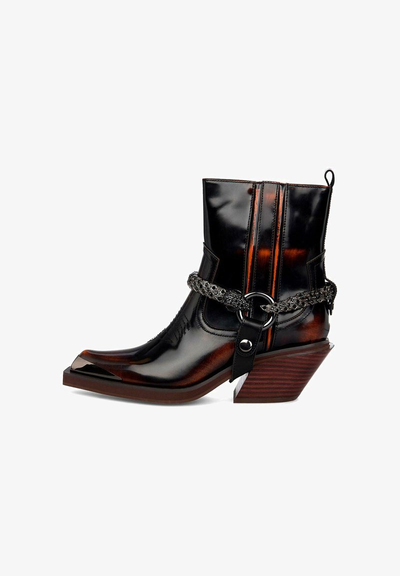 Botín de tobillo de cuero negro pulido con punta afilada, acentos metálicos, detalle de cadena intrincado y un tacón de madera esculpido.