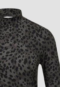 Leopard print high-neck top featuring a grey background with black spots, made of soft fabric, with a fitted design and long sleeves.