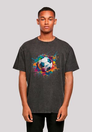 Black oversized t-shirt featuring a colorful splatter design with a soccer ball at the center. Cotton material with a relaxed fit and short sleeves.