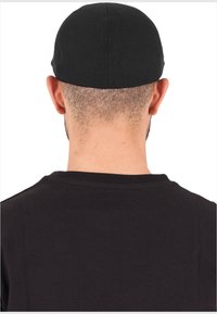 Black fitted cap made of soft fabric, featuring a smooth texture and minimalist design with no visible embellishments.