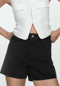 Črne denim kratke hlače z visokim pasom, z sprednjimi žepi in kovinskim gumbom za zapiranje. Gladka tekstura s klasičnim krojem.