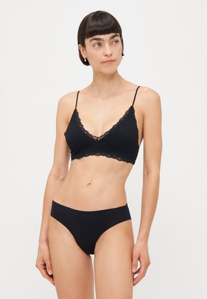 Bralette nera in pizzo con spalline regolabili e forma triangolare, abbinata a slip bikini neri coordinati. Materiale morbido e liscio.