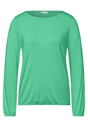 Camicia verde a maniche lunghe con scollatura rotonda, realizzata in un tessuto morbido. Presenta polsini arricciati e un taglio leggermente loose all'orlo.