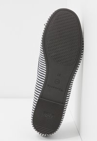 Gestreifter Slipper mit einem Obermaterial aus Stoff in Marineblau und Weiß, ausgestattet mit einer strukturierten Gummisohle und Branding an der Ferse. Größe 37.