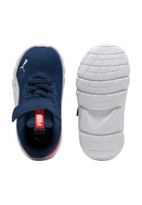 Zapatillas deportivas azul marino con parte superior de malla, cordones de tela, correa ajustable y suela texturizada blanca. Acento rojo en el talón.