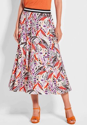 Jupe évasée en tissu léger avec un motif floral et de feuilles vibrant en rouge, violet et noir. Dotée d'une taille élastique noire.