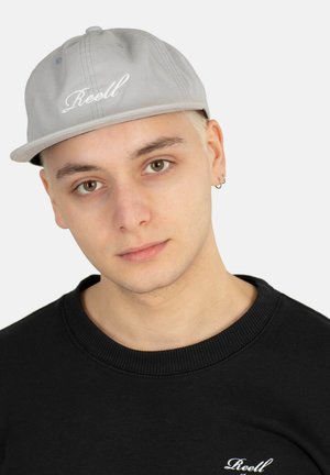Gray baseball cap with white embroidered "Reell" logo, featuring a flat brim and six-panel design. Worn with a black sweatshirt.