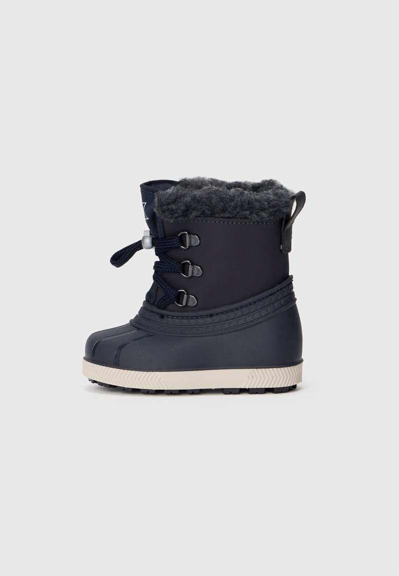Botte d'hiver noire unique avec semelle blanche épaisse, fermeture à lacets sur le devant et doublure en polaire grise douce visible en haut.
