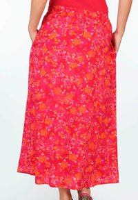 Langer, floral bedruckter Rock mit einem lebhaften pinken Hintergrund und orangefarbenen sowie gelben Blumen. Elastischer Taillenbund und Seitentaschen für zusätzlichen Komfort.