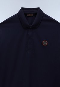 Dunkel marineblaues Poloshirt mit umgelegt-klappbarem Kragen und kleinem rundem orange-schwarzem Logo auf der linken Brust.