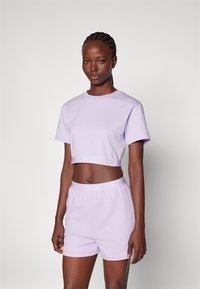 T-shirt lavande coupé et short assorti avec le logo HUGO sur la ceinture. Tissu doux et lisse avec des manches courtes et une coupe décontractée.