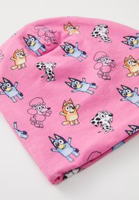 Rosa Baumwollmütze mit verschiedenen Comic-Hundcharakteren in mehreren Farben. Das Design umfasst verspielte Posen und markante, leuchtende Details.