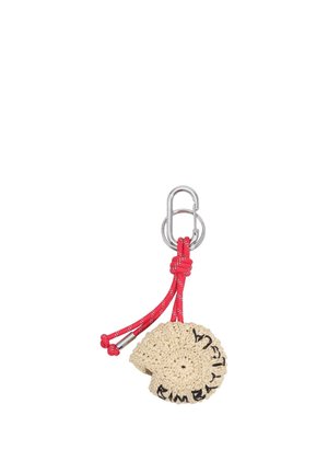 Llavero beige de concha hecho a ganchillo, unido a un mosquetón plateado con cuerda roja y puntas metálicas, con texto bordado en negro.