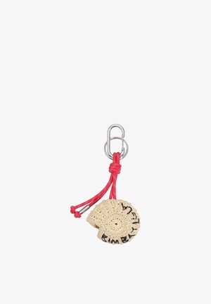 Llavero beige de concha hecho a ganchillo, unido a un mosquetón plateado con cuerda roja y puntas metálicas, con texto bordado en negro.