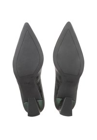 Paire d'escarpins noirs à bout pointu, vus de la semelle, taille 4½, avec talons texturés et nom de marque « högl » sur la semelle.