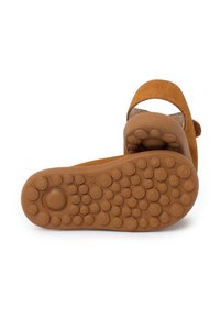 Brown suede sandals with a textured rubber sole, featuring circular grip patterns and an open back design for breathability.