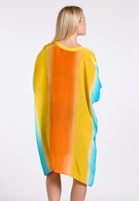 Vloeiende kaftan in een gradient van oranje, geel en turkoois. Lichtgewicht stof met een losse pasvorm en een ronde halslijn.