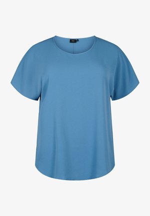Blouse bleue à manches courtes avec un décolleté rond, en tissu lisse, présentant une coupe ample et décontractée avec un ourlet arrondi.