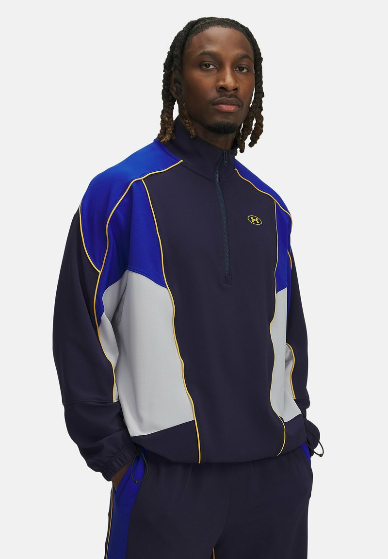 Sudadera de media cremallera de color marino con acentos en azul, gris y amarillo; cuenta con un cuello alto y puños elásticos para un ajuste ceñido.