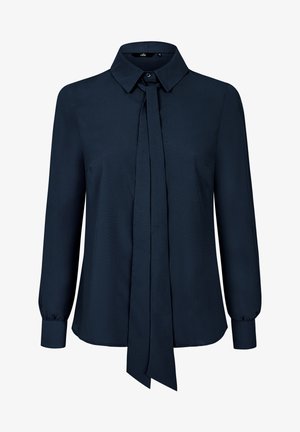 Granatowa bluzka z wyopisanym kołnierzykiem, z przodem wiązanym, długimi rękawami i mankietami na guziki. Wykonana z gładkiego materiału o lekko połyskującej fakturze.