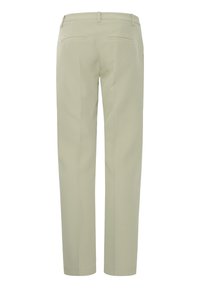 Pantalon beige sur mesure avec passants pour ceinture et deux poches passepoilées à l'arrière, présenté de dos sur un fond blanc uni.