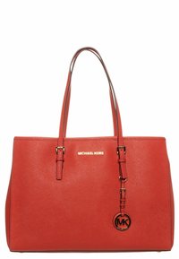Sac tote en cuir rouge avec doubles poignées, quincaillerie dorée et logo Michael Kors. Il présente un charme circulaire MK et une surface texturée.