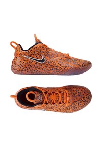 Scarpe da ginnastica arancioni con un motivo a pois nero, suola in gomma e parte superiore testurizzata. Presentano il logo Nike nero e chiusura con lacci.