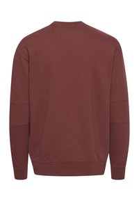Maroon dukserica, pamučni materijal, okrugli izrez, duge rukave, rebrasti manžeti i rub, glatka tekstura, bez vidljivih logotipa ili uzoraka.