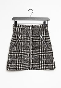 Svart och vit rutigt kjol med en texturerad tyg, med en centrerad dragkedja och två sidofickor med silverdetaljer.