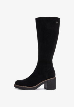 Bota de ante negra hasta la rodilla con tacón cuadrado, que presenta un borde cosido y un pequeño acento de metal en el costado. Textura suave.