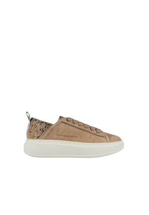 Lavprofileret beige ruskind sneaker med tyk hvid sål, dekorativ hæl med rhinsten, snørelukning foran og "Alexander Smith" branding på siden.