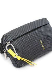 Svart texturerad tygväska med metallbeslag, gul accent, dragkedjestängning och logodetalj; kompakt rektangulär form, lämplig för olika föremål.