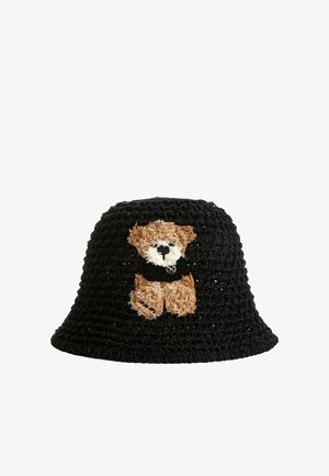 Sombrero tipo bucket de crochet negro con un oso de peluche marrón texturizado que lleva un suéter negro bordado en el frente.