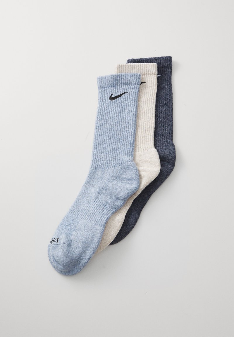 Tri par sock: svetlo modre, kremaste in temno modre; rebrasta tekstura z črnim Nike logotipom na vsakem. Mešanica bombaža.