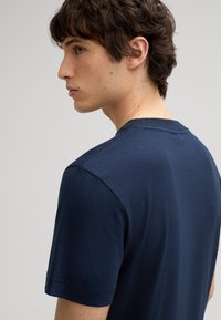 Navyblauw T-shirt met korte mouwen, gemaakt van zacht katoen, met een klassieke ronde hals en een gladde, gelijkmatige textuur met minimale stikdetails.