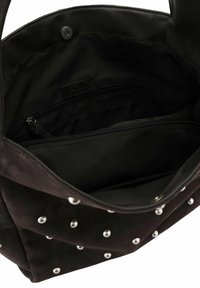 Intérieur de sac à main en daim noir avec des compartiments zippés, texture lisse, clous en argent à l'extérieur et fermeture à pression magnétique.