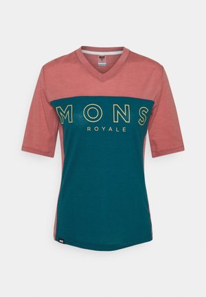 Lyhythihainen, V-pääntie t-paita pinkissä ja teal-värissä, jossa rinnassa lukee "MONS ROYALE" lihavoinnilla keltaisilla kirjaimilla. Pehmeä kangas, rento istuvuus.