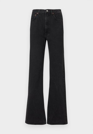 Black flared jeans with a high waist, made of denim. Features five pockets and orange stitching accents. Smooth texture with a classic cut.