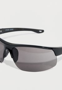 Μαύρα γυαλιά ηλίου με σχεδιασμό που αγκαλιάζει το πρόσωπο, γκρι φιμέ φακούς και λείες πλαστικές σκελετούς. Φέρουν το όνομα της μάρκας "Pier One" στο πλαϊνό μέρος.