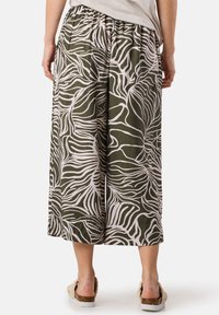 Pantaloni a gamba larga in tessuto verde oliva con un motivo astratto di foglie beige. Vita elastica e vestibilità ampia per il massimo comfort.