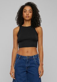 Zwarte cropped tanktop met een getailleerd ontwerp en een ronde halslijn, gecombineerd met hoge blauwe denimbroek met zakken en knoopsluiting.