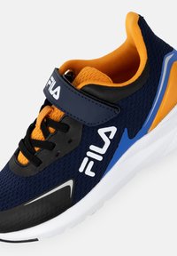 Sneaker FILA blu navy e arancione con lacci neri, cinturino con velcro, suola bianca e dettagli blu e gialli.