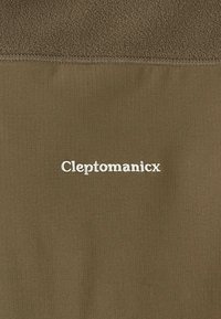 Olivgrüne Fleecejacke mit geripptem unteren Abschnitt, ausgestattet mit weiß gesticktem Text "Cleptomanicx" im Brustbereich.