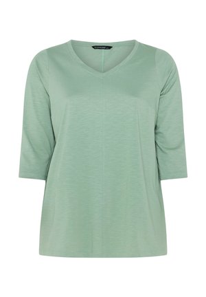 Maglietta verde chiaro da donna con maniche a tre quarti e scollo a V, realizzata in tessuto morbido leggermente strutturato.