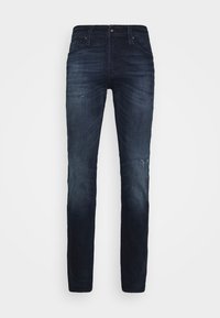 Mörkblå jeans i slim fit med lätt slitningar vid knäna, klassisk femfickorsdesign och metalldesign med knäppning.