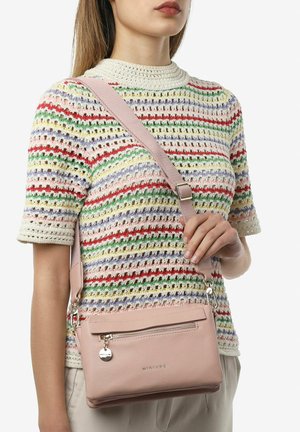 Lichtroze leren crossbody tas met een ritsvak aan de voorkant en een afneembare schouderriem, met eenvoudige hardware en een gladde afwerking.