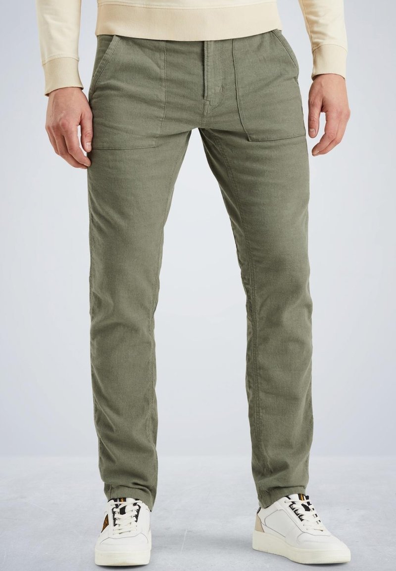 Pantalones de algodón verde olivo con corte recto, que cuentan con bolsillos frontales y una tela texturizada, combinados con zapatillas blancas.