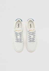 Sneakers bianchi con tomaia in pelle liscia, dettagli blu e lacci con motivo blu e bianco. Presentano un design perforato nella zona delle dita.