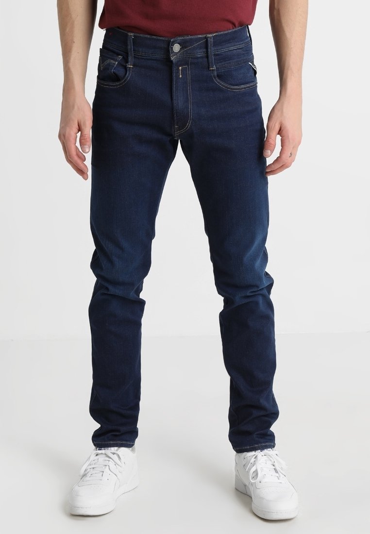 Mörkblå denimjeans med en smal passform, utrustade med två framfickor och en liten myntficka, avslutade med en metallknapp och dragkedjegylf.